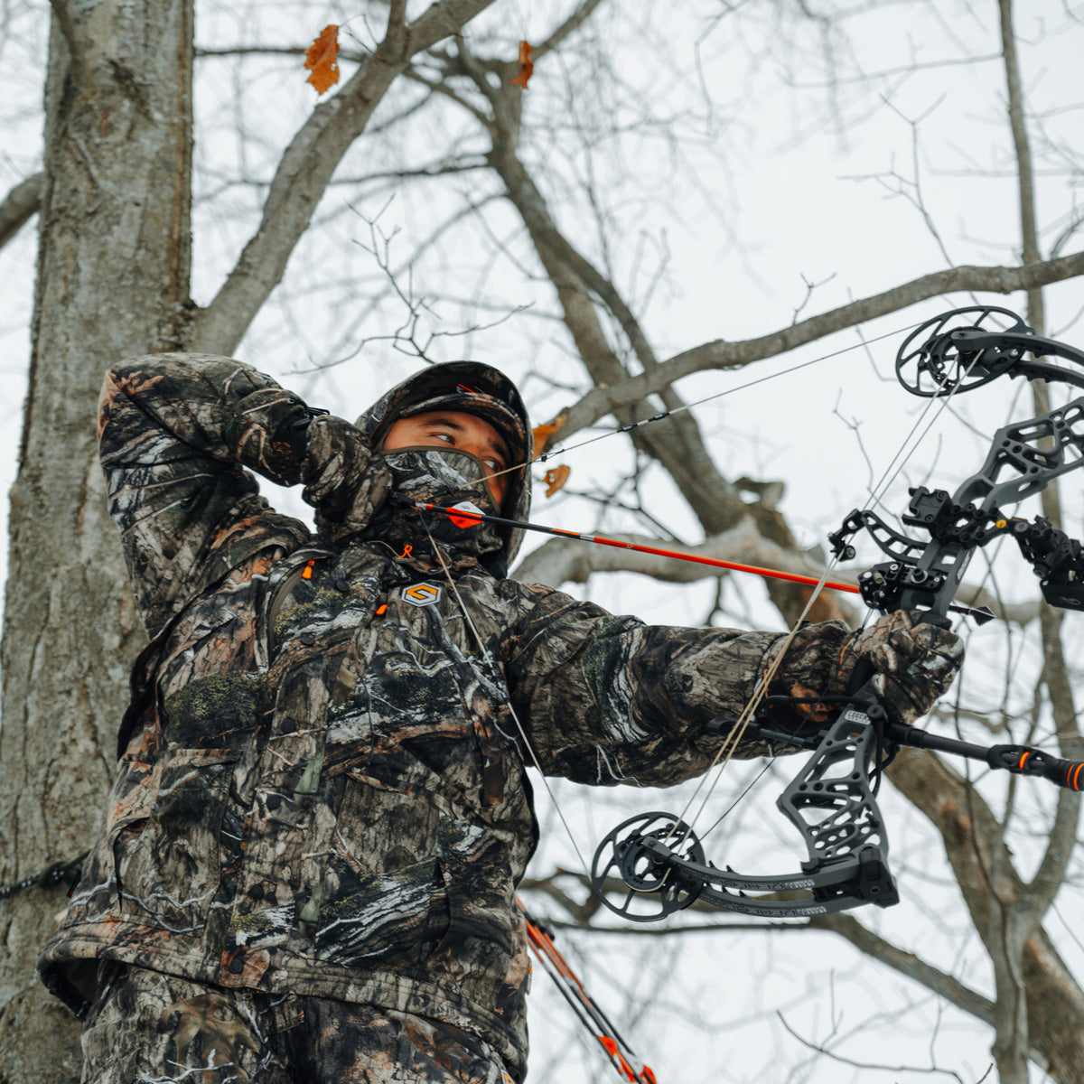 hunter wearing alpha elite drawingn a bow in a tree stand