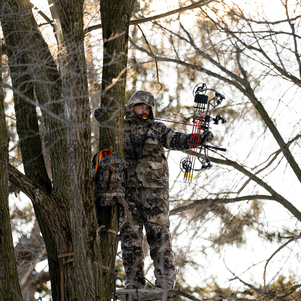 hunter wearing fortress in the tree stand drawing a bow